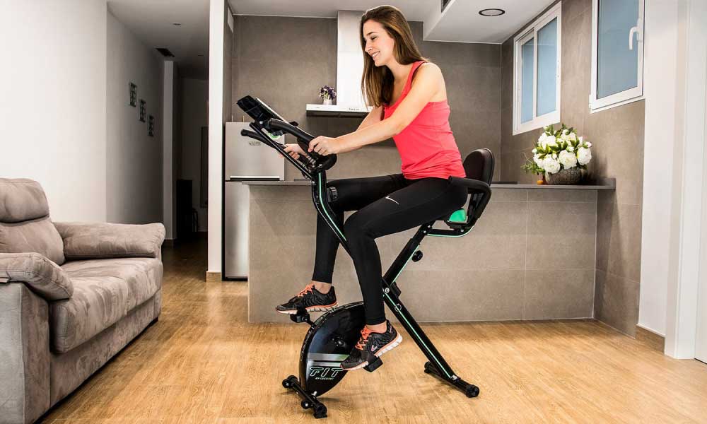 Mujer entrenando en una bicicleta estática cecotec